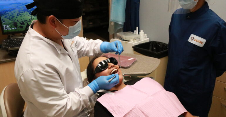 Dentist cleaning patients teeth